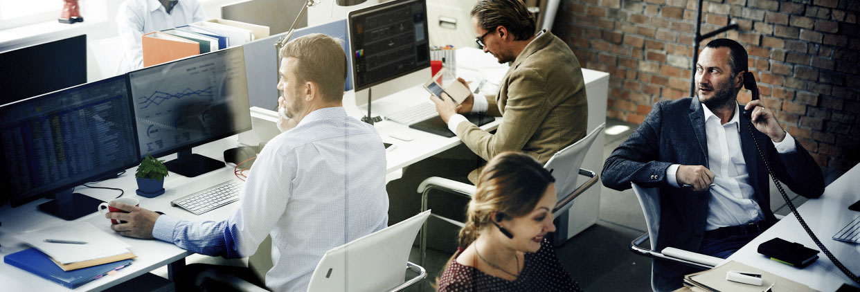 Group of call centre employees working at desks in an office setting.