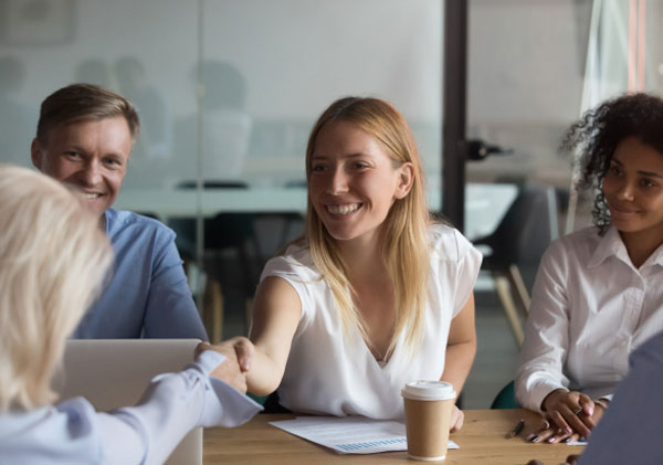 A diverse group of professionals shaking hands at a business meeting.