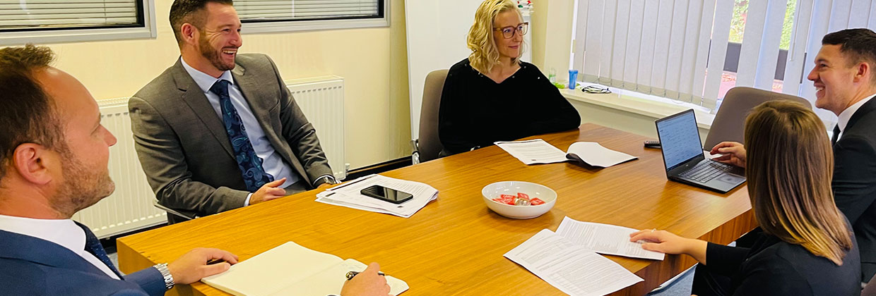 A team of professionals discussing ideas and collaborating at a conference table in an office setting. Market Location, team members